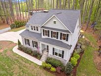 Two-story home featuring stone accents, a gray facade, a landscaped front yard, and a welcoming front porch at 749 Bowden Rd, Chapel Hill, NC 27516