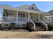 Charming home featuring a welcoming front porch with brick steps and white railings at 1130 N Roxboro St, Durham, NC 27701