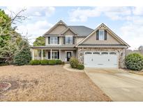 Charming two-story home featuring a manicured lawn, stone accents, and a welcoming front porch at 1426 Phelps Ridge Dr, Fuquay Varina, NC 27526