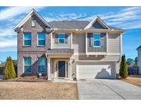Charming two-story home featuring a brick facade, well-manicured lawn, and attached two-car garage at 197 Royal Oak Ln, Garner, NC 27529