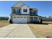 Charming two-story home with a two-car garage and well-maintained lawn, perfect for Gathering living at 39 Stegman Ln, Dunn, NC 28334