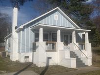 Charming home with light blue painted wood and brick porch with craftsman railing at 523 E Nelson Ave, Wake Forest, NC 27587