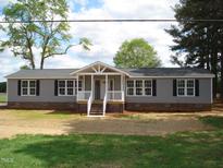 Charming ranch-style home featuring gray siding, black shutters, and a welcoming front porch at 5780 Plain View Hwy, Dunn, NC 28334