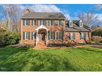 Charming brick home featuring a well-manicured lawn, black shutters, and inviting front porch at 6320 Bayswater Trl, Raleigh, NC 27612