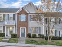 Charming townhome exterior with brick accents, manicured lawn, and inviting entry steps at 706 Canyon Lake Cir, Morrisville, NC 27560