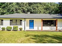 Charming home featuring a bright blue front door, black shutters, and well-maintained landscaping at 7414 Virgilina Rd, Roxboro, NC 27574