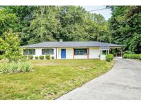 Charming single-story home featuring a bright blue front door and a covered parking area at 7414 Virgilina Rd, Roxboro, NC 27574