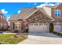 Charming brick townhome with stone accents and a two-car garage, showcasing curb appeal and architectural details at 1126 Talisker Way, Burlington, NC 27215