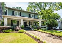 Charming two-story home with a brick walkway, covered front porch and manicured landscaping at 1200 Glenwood Ave, Raleigh, NC 27605