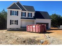 Charming two-story home with attached garage, black roof, and an empty lot at 122 Reece Dr, Sanford, NC 27332