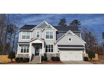 Charming two-story home with a classic gray exterior and well-manicured front yard at 1520 Village Grove Ct, Hillsborough, NC 27278