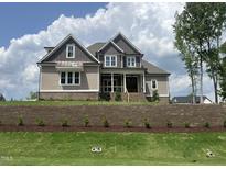 Beautiful two-story home with gray and brown siding, brick foundation, and manicured lawn at 165 Cotton Fields Ln # 25, Fuquay Varina, NC 27526