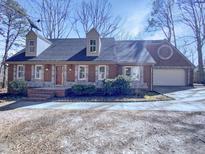 Charming brick home featuring a two-car garage and dormer windows at 204 Colonial Dr, Clayton, NC 27527