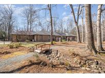 Stunning single-story brick home with beautiful landscaping and a charming bridge feature at 221 Saddle Ridge Rd, Chapel Hill, NC 27514