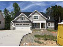 Beautiful two-story home with gray siding, stone accents, black roof, and a spacious two car garage at 309 Deer Tail Ln # 42, Fuquay Varina, NC 27526