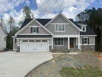 Charming two-story home with a gray exterior, a two-car garage, and a well-manicured lawn at 309 Deer Tail Ln # 42, Fuquay Varina, NC 27526