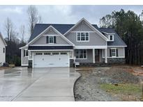 Charming gray home featuring a two-car garage, stone accents, and a classic craftsman design at 309 Deer Tail Ln # 42, Fuquay Varina, NC 27526