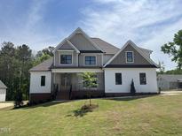 New construction with white siding, gray accents, front porch, and professionally-landscaped front yard at 318 Deer Tail Ln # 35, Fuquay Varina, NC 27526