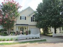 Charming two-story home with light yellow siding and a white picket fence at 5040 Dawn Piper, Raleigh, NC 27613