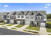 Charming row of new construction townhomes with brick accents and well manicured lawns at 605 Leland Hl Cir, Zebulon, NC 27597