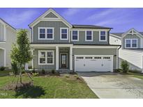 Charming two-story home with gray siding, a two-car garage, and a well-maintained lawn at 63 Daybreak Way, Fuquay Varina, NC 27526
