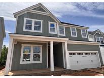 Charming two-story home with board and batten siding, white trim, and a two-car garage at 63 Daybreak Way, Fuquay Varina, NC 27526