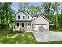 Charming two-story home features a covered porch, two-car garage, and a well-maintained lawn at 632 Angus Ct, Sanford, NC 27332
