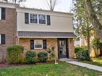 Charming two-story home with brick and siding, complemented by dark shutters and lush landscaping at 6525 New Market Way, Raleigh, NC 27615
