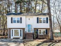 Charming two-story home with brick accents and a well-maintained front yard, nestled among mature trees at 7704 Cresthill Ct, Raleigh, NC 27615