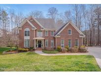 Beautiful brick home boasts a manicured lawn, mature trees and a welcoming front entrance at 8015 Papaya Dr, Raleigh, NC 27613