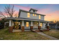 Charming two-story home featuring a spacious covered porch with brick supports and white trim at 802 N Elizabeth St, Durham, NC 27701