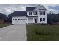 Charming two-story home featuring a two-car garage, dark shutters, and a well-manicured lawn at 81 Reece Dr, Sanford, NC 27332