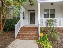 Charming front porch with brick steps, white railings, and inviting entrance at 1012 Palace Garden Way, Raleigh, NC 27603