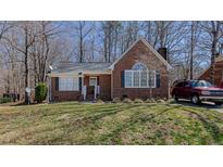 Charming brick home features a manicured lawn and a neatly paved driveway with a red SUV at 1253 Skyview Dr, Mebane, NC 27302