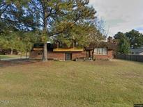 Charming brick home with a spacious front yard and mature trees providing ample shade at 1617 Chase St, Rocky Mount, NC 27801