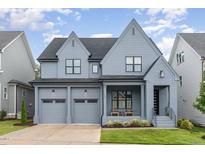 Beautiful, two-story home featuring gray siding, black trim, two-car garage, and charming front porch at 183 Post Oak Rd, Chapel Hill, NC 27516