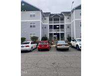 Exterior shot of apartment building with multiple levels and parking area, offering convenience and community living at 2002 Technology Woods Drive # 103, Raleigh, NC 27603