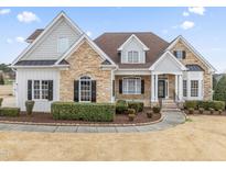 Inviting exterior elevation showcasing a blend of stone and siding, manicured landscaping, and a welcoming entrance at 2021 Rockwall Farms Ln, Fuquay Varina, NC 27526