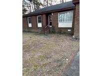 A charming single-story brick home with red trim, surrounded by a lawn that requires refreshing at 208 Essex Rd, Nashville, NC 27856