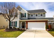 Charming two-story home featuring a two car garage and manicured front lawn at 2344 Lazy River Dr, Raleigh, NC 27610