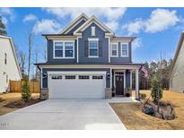 Charming two-story home with a two-car garage, blue siding, and manicured front yard at 2515 Maplemere Ct, Durham, NC 27703