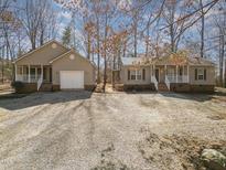 Charming homes with a large gravel driveway and well-maintained lawns offer a welcoming curb appeal at 3011 Little Creek Ln, Hillsborough, NC 27278