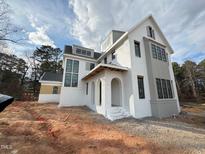 Striking white exterior with black trim and arched entry provides timeless appeal at 3321 Founding Place, Raleigh, NC 27612