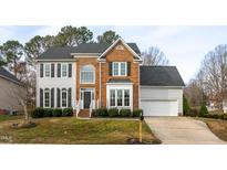 Traditional two-story brick and siding home with well-manicured landscaping and a two-car garage at 3528 Dewing Dr, Raleigh, NC 27616