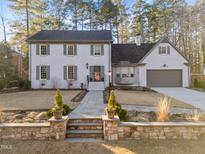 Charming two-story home with a brick facade, walkway, manicured lawn, and mature trees at 3930 St. Marks Rd, Durham, NC 27707