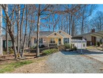Charming one-story home featuring a cozy porch, a gravel driveway, and a convenient carport on a sunny day at 4901 North Pointe, Sanford, NC 27332