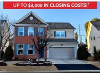 Charming two-story home featuring brick facade, blue shutters, and an attached two-car garage at 508 Stapleford Ln, Fuquay Varina, NC 27526