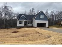 Charming home featuring a mix of blue and grey siding, an attached garage, and a cozy covered front porch at 5389 Salem Woods Dr # 12, Graham, NC 27253