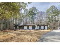 Charming home with a long driveway surrounded by natural landscaping and tall trees at 5711 Craig Rd, Durham, NC 27712