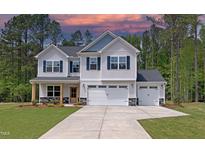 Two-story home with a three-car garage, blue shutters, and a well-manicured lawn against a backdrop of lush green trees at 6800 Franklin Heights Rd, Cary, NC 27518